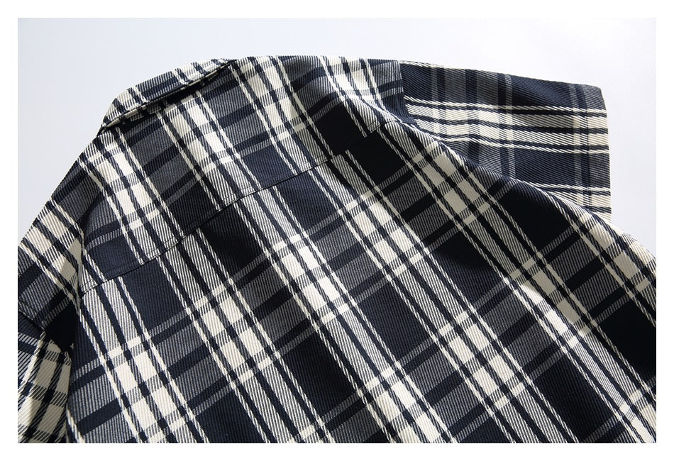 Close-up of the shirt's navy, black, and cream plaid back with a horizontal yoke seam.