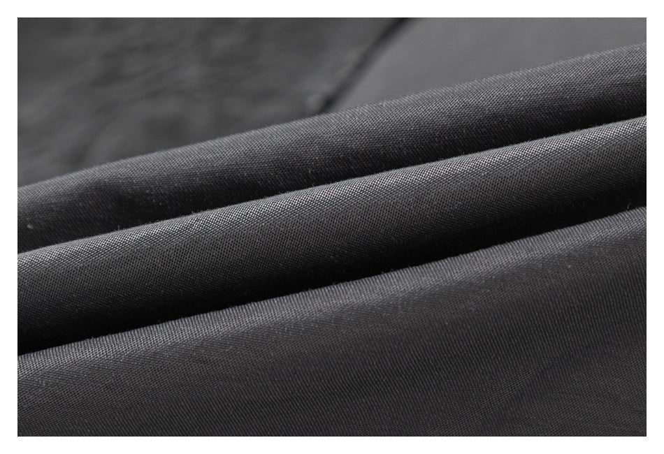 Extreme close-up of charcoal fabric showing its fine woven surface and folds.