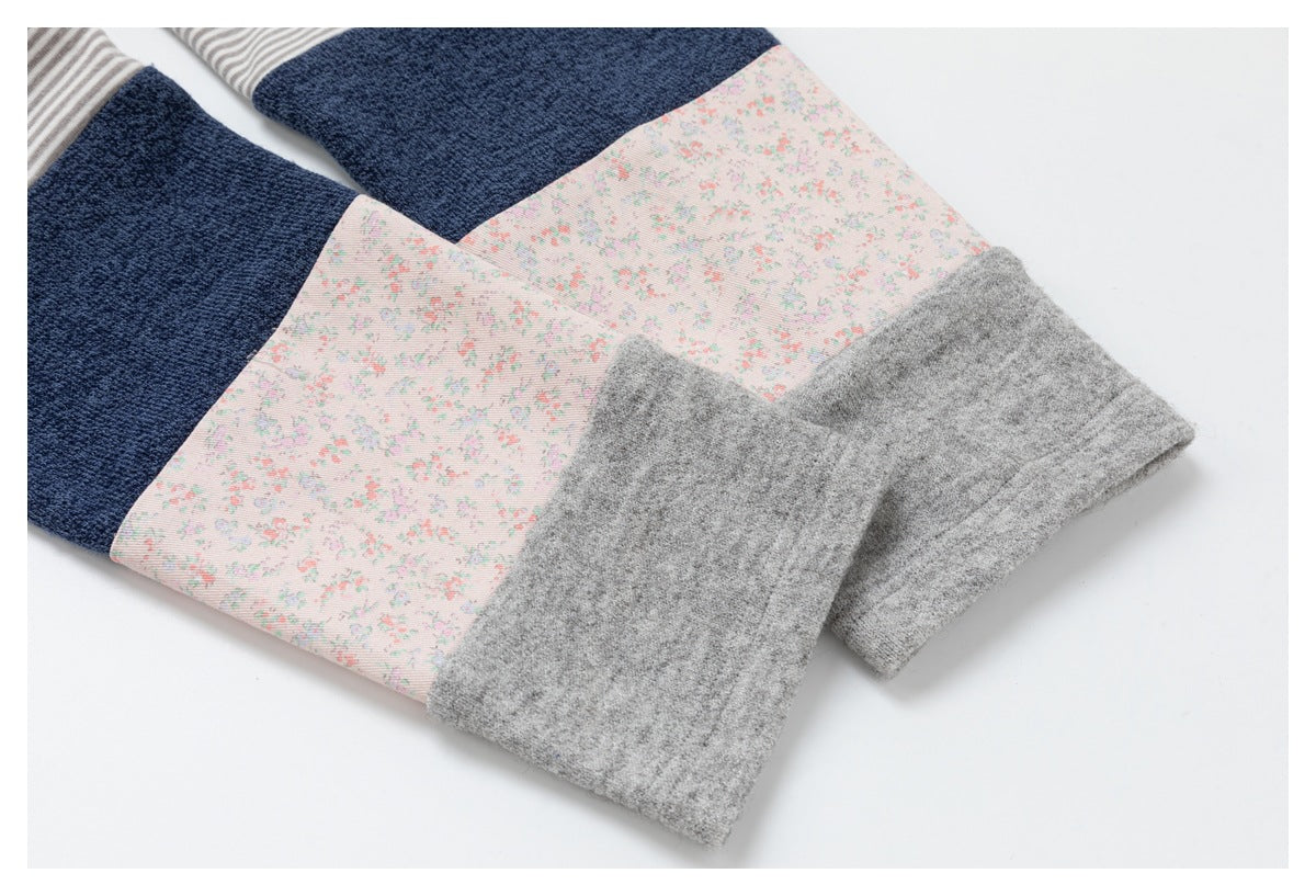 Close-up of garment sleeves with striped, navy, floral, and heather gray color-block panels.