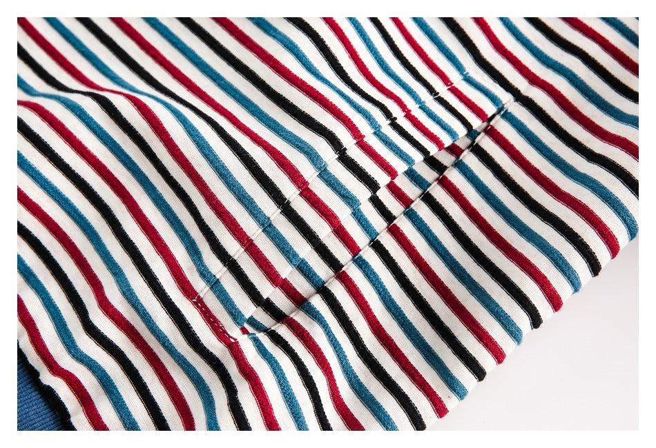 Close-up of the striped jacket’s stitched hem and fabric, with a section of blue ribbed trim visible.