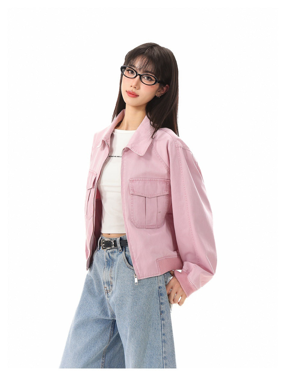 Model in pink cropped zip jacket with collar and flap pocket, partly open over a white top and light blue jeans