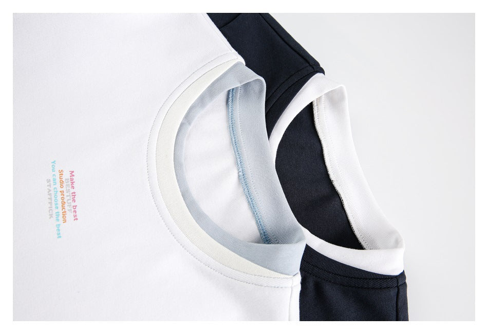 Close-up of white and black T-shirt necklines showing contrasting collar bands and small printed chest text.