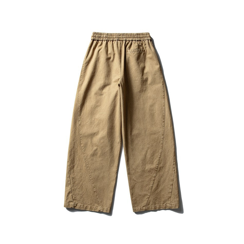 Back view of tan wide-leg trousers with a gathered elastic waistband and a small rear pocket.