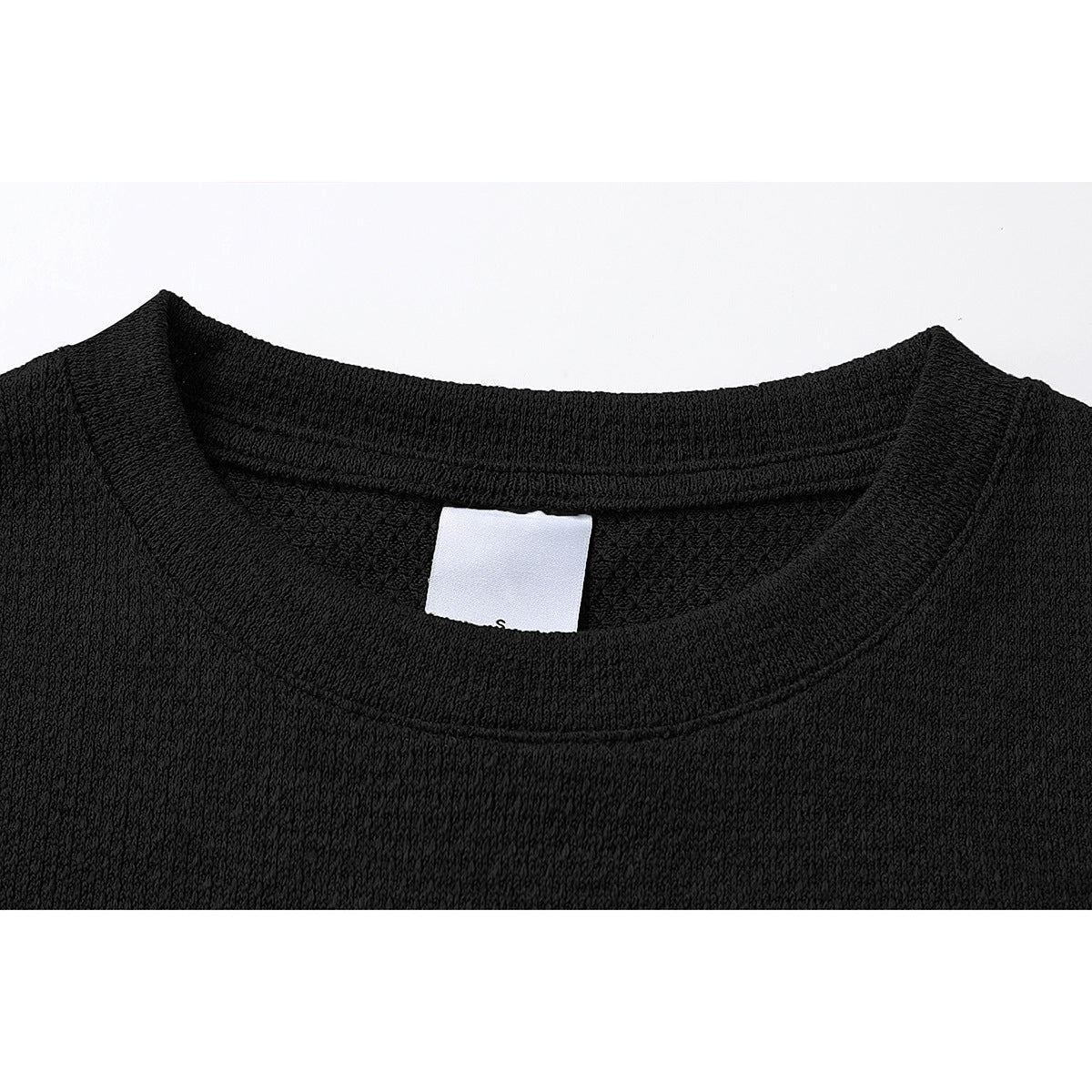 Close-up of a black crew-neck T-shirt collar and inner white label.