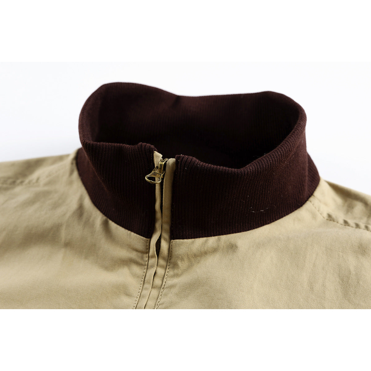Close-up of a khaki jacket with a dark brown ribbed stand collar and front zipper.