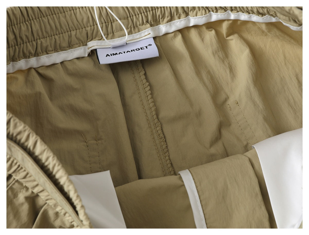 Inside close-up of beige shorts showing the waistband lining, seam finishing and a sewn-in brand label.