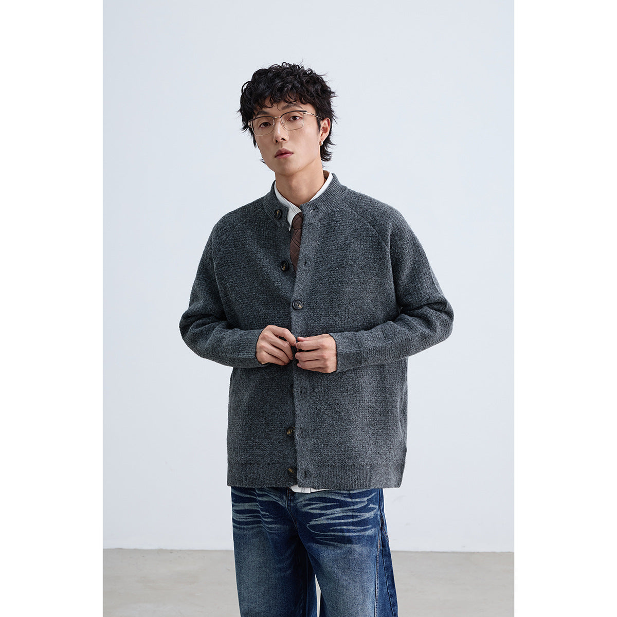 Model wearing a charcoal gray button-front cardigan, shown from the front with blue jeans.