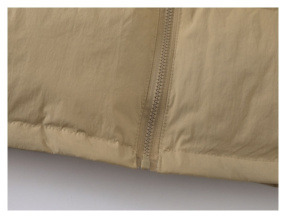 Close-up of a beige jacket hem and matching center zipper.