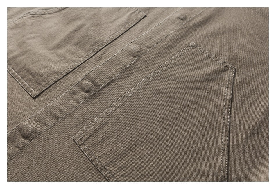 Close-up of the olive-brown shirt's button placket and large stitched patch pocket.