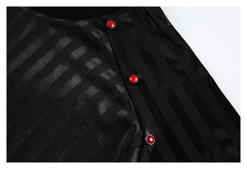 Close-up of a black striped top with a shoulder placket and three red buttons.