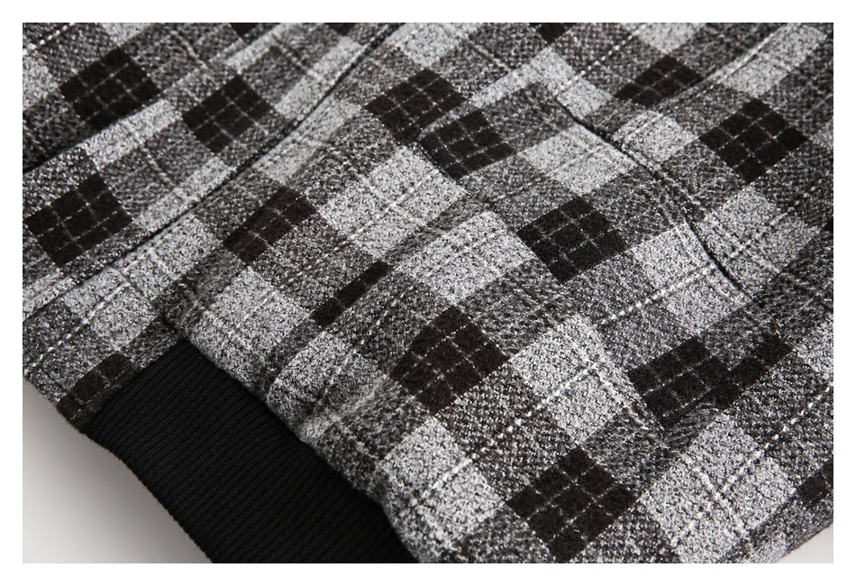 Close-up of the plaid jacket fabric, a seam, and the black ribbed hem.