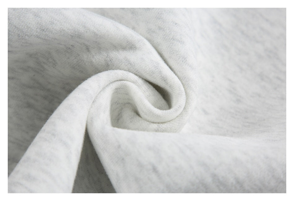 Close-up of light gray marled fabric gathered into a soft spiral fold.