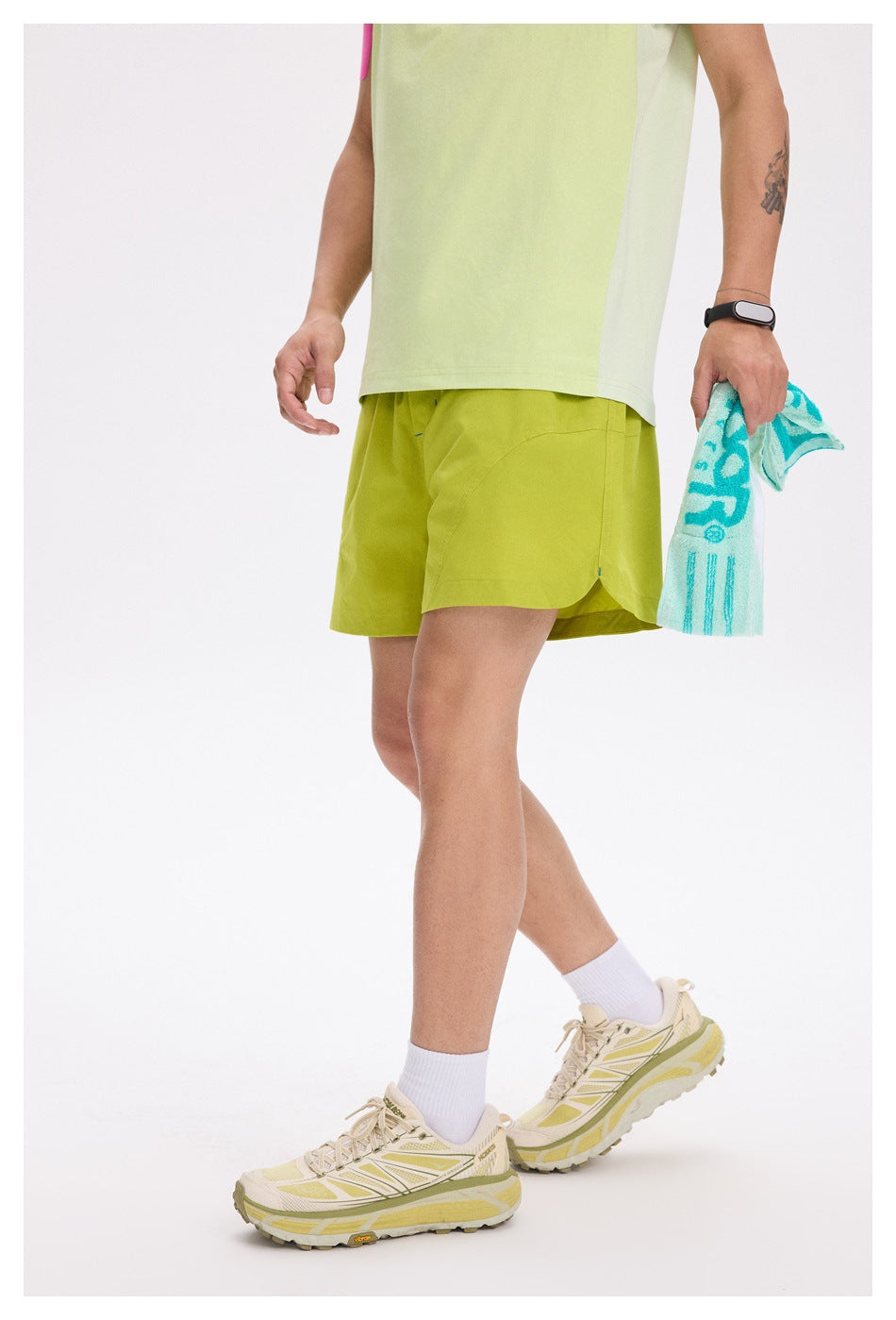 Cropped model wearing lime-green shorts, shown from the side with curved pocket seams.
