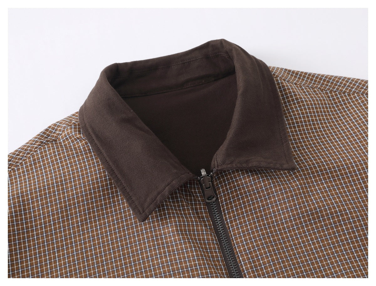 Close-up of a brown checked jacket front with a solid dark brown collar and center zipper.