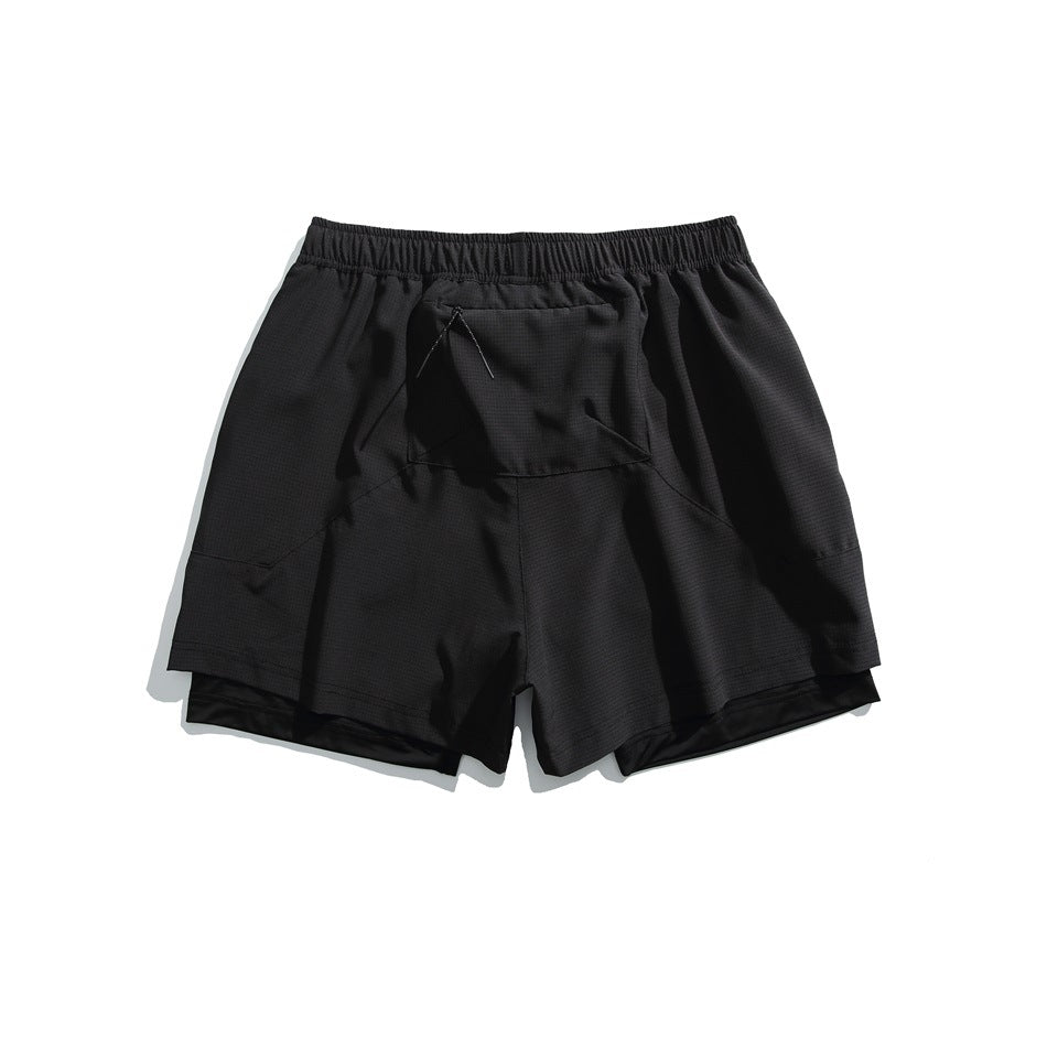 Black layered athletic shorts, back view, with an elastic waistband, center rear pocket and black inner shorts.