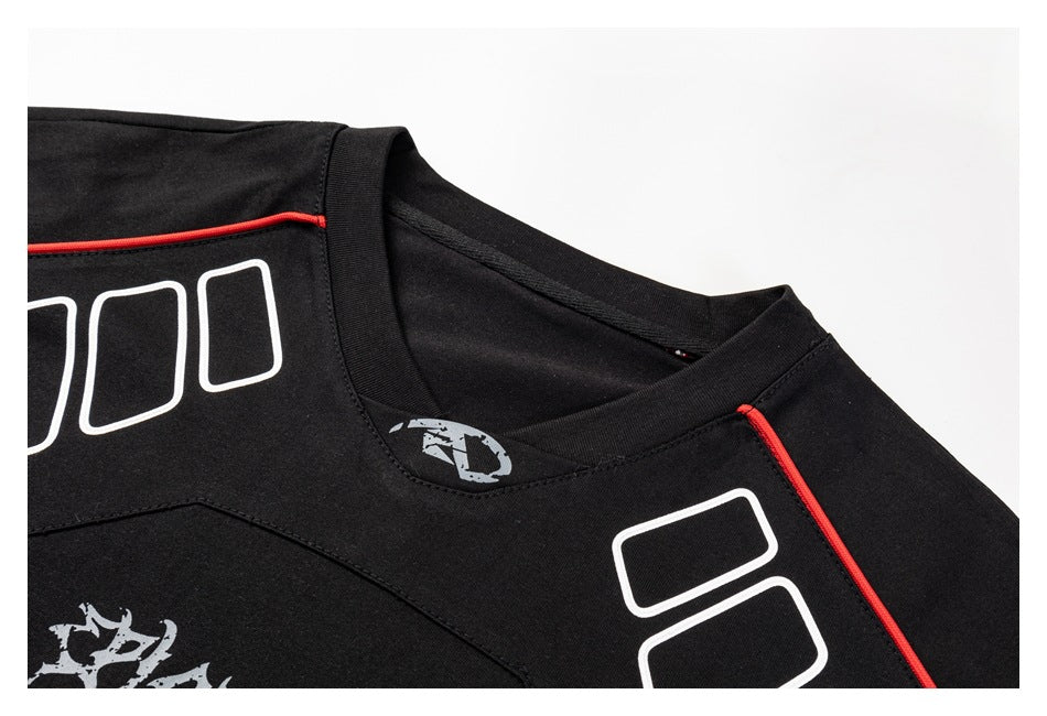 Close-up of a black shirt's collar and shoulder, with red piping and white and gray printed graphics.