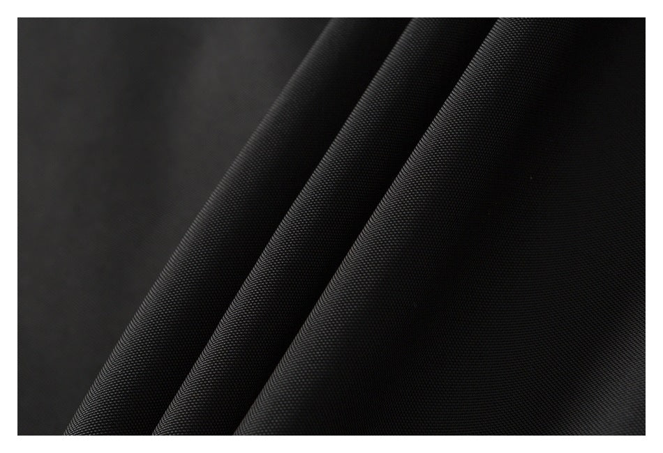 Close-up showing the fine textured surface of the black jacket fabric in folded layers.