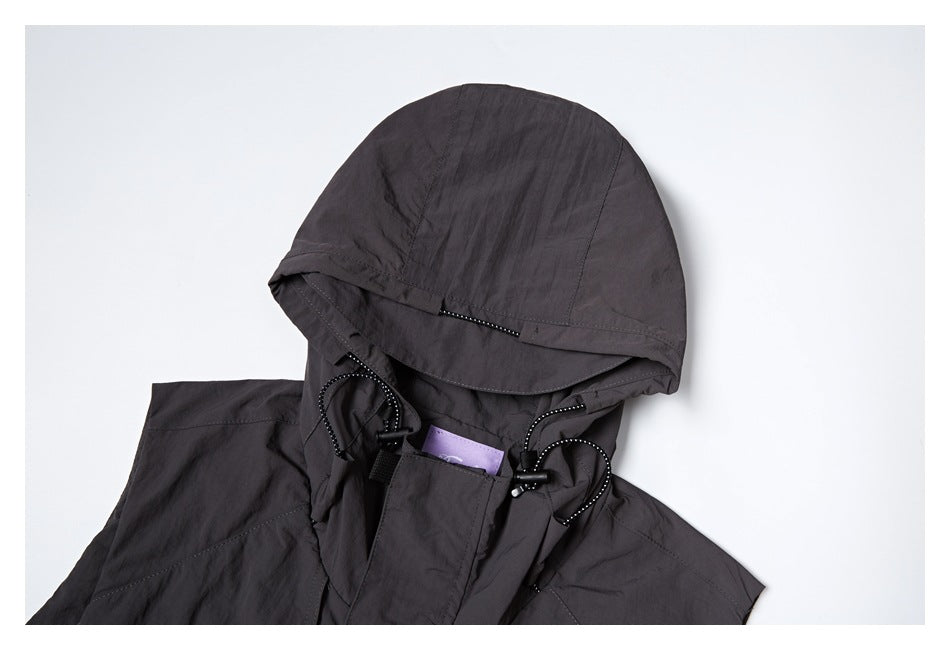 Close-up of the charcoal vest's hood, showing the brim and adjustable drawcords with toggles.