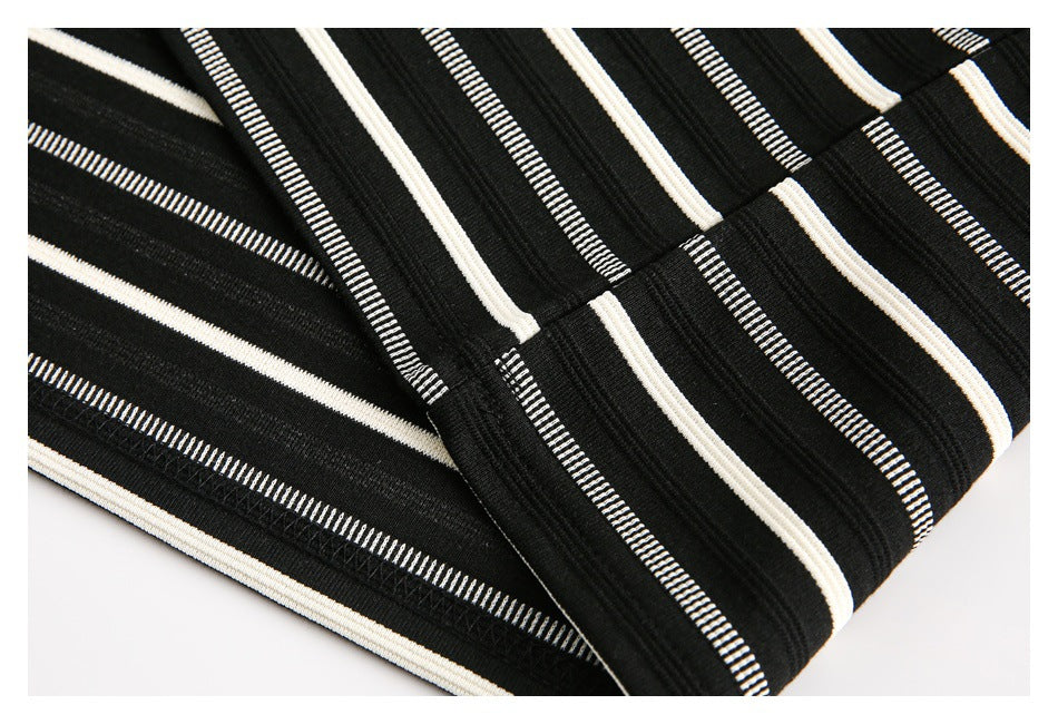 Close-up of striped black fabric showing a folded edge and visible stitching.