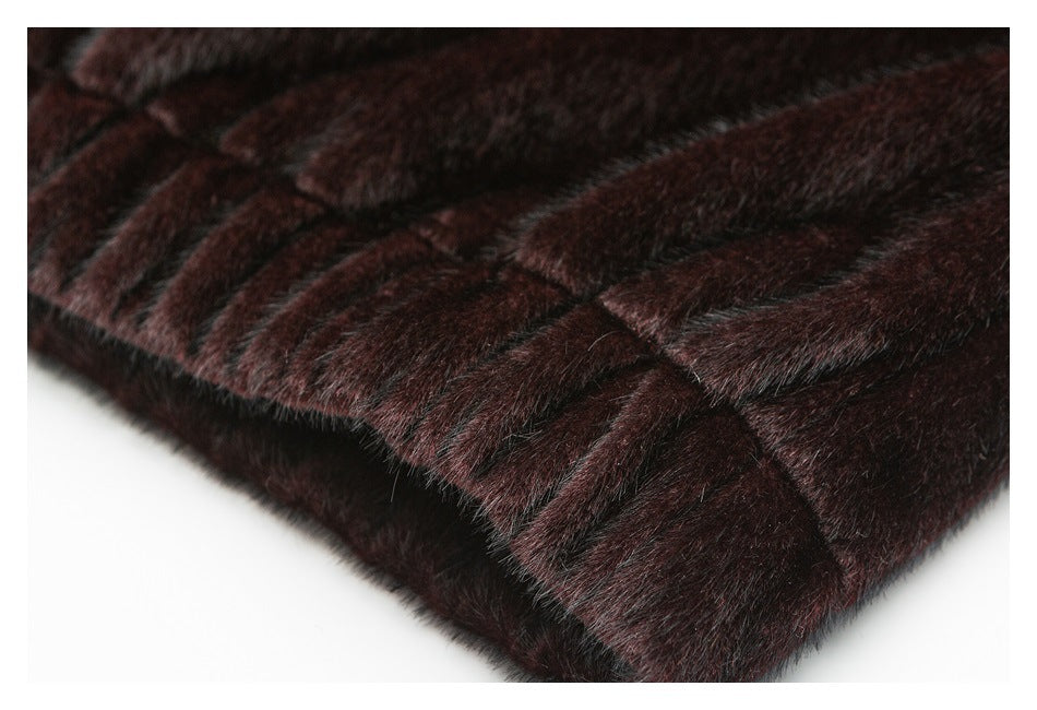 Close-up of dark burgundy plush fabric with stitched panels and a finished edge.