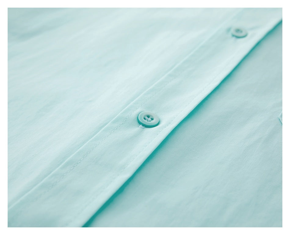 Close-up of an aqua button and stitched front placket.