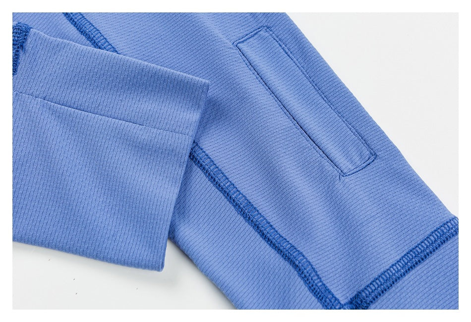 Close-up of a blue garment with a rectangular stitched tab and reinforced seams.