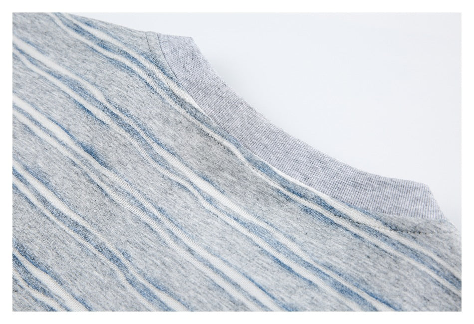Close-up of a ribbed gray neckline beside gray, blue, and white striped knit fabric.
