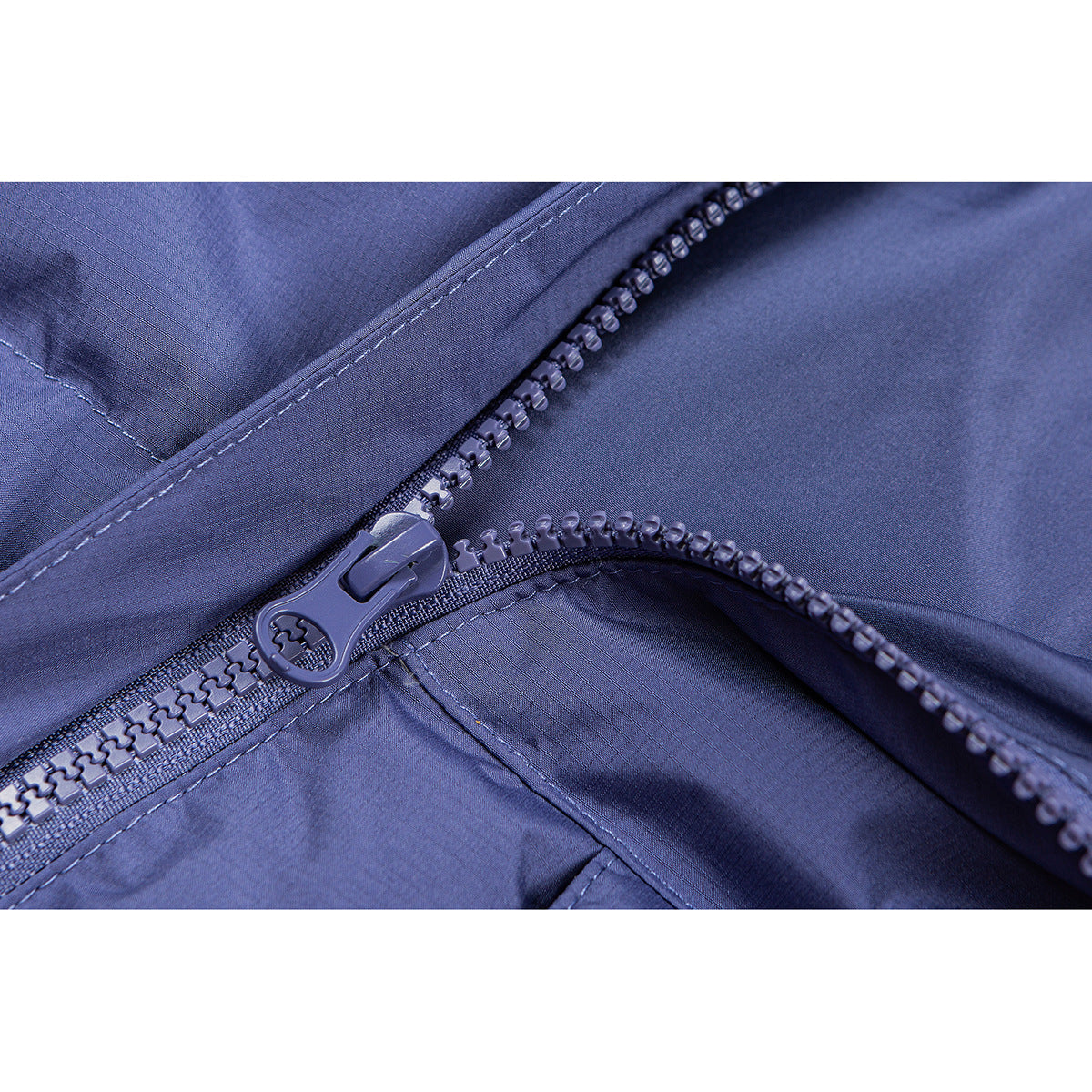 Close-up of a blue jacket's chunky front zipper and stitching.
