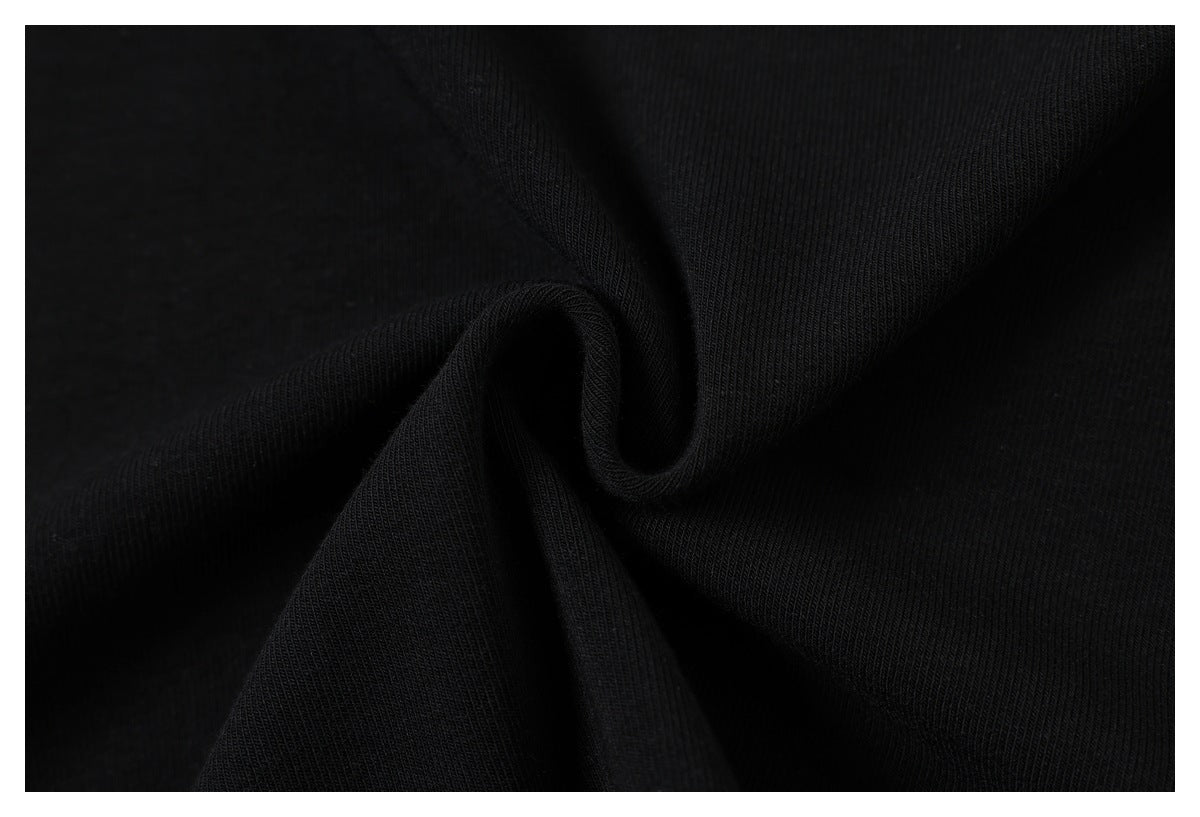 Close-up of black knitted fabric gathered into soft folds, showing its fine ribbed texture.