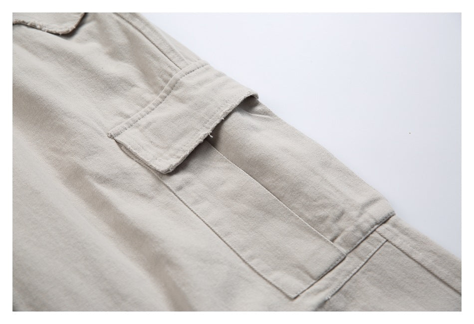 Close-up of a beige side cargo pocket and its flap on the pants.