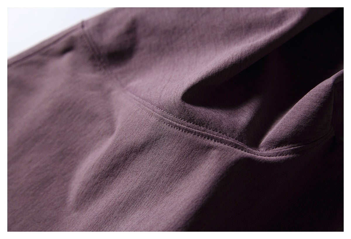 Close-up of plum T-shirt fabric and a curved stitched seam.