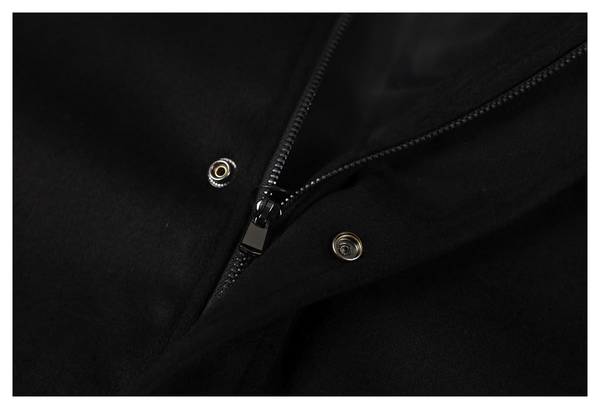 Close-up of the black jacket's front zipper and metal snap fasteners.