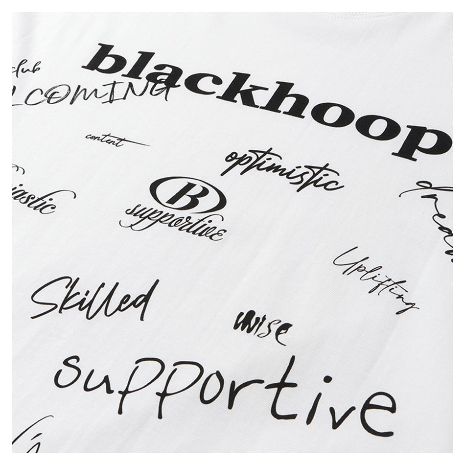 Close-up of a white garment printed with assorted black words and script lettering.