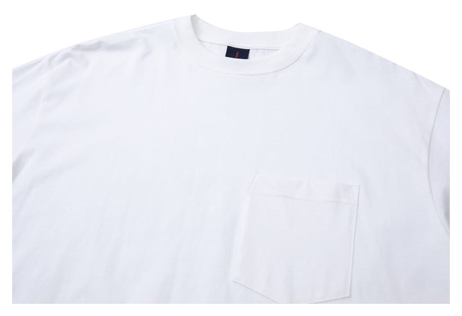 Close-up of a white crew-neck shirt showing its chest pocket and collar.