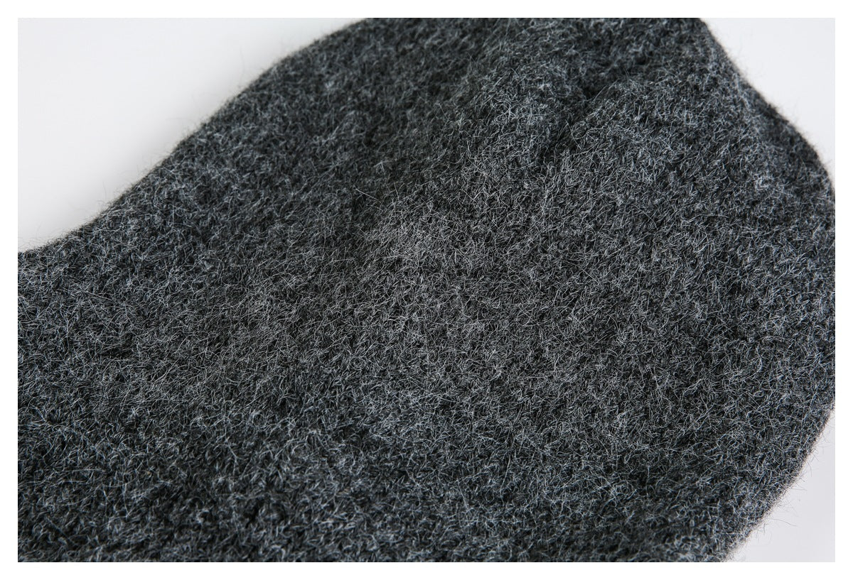 Extreme close-up of dark charcoal gray fuzzy knit fabric against a white background.