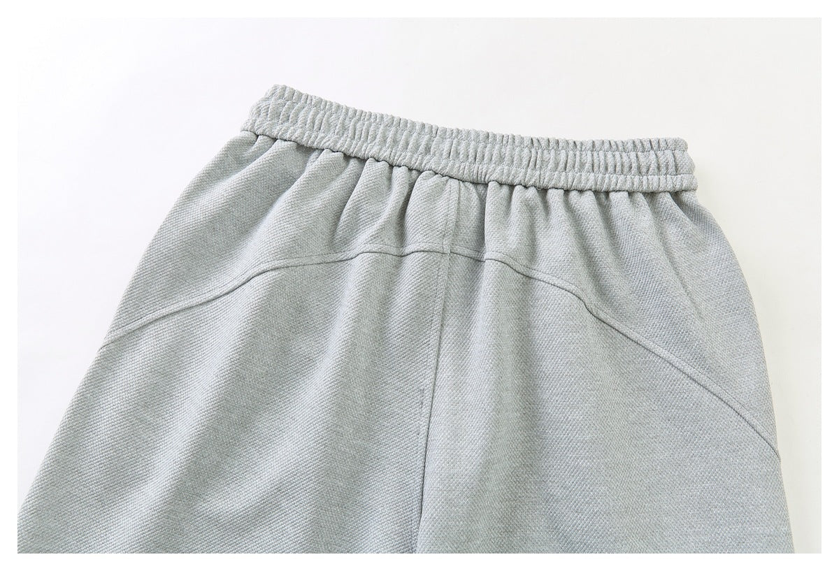 Close-up of pale gray bottoms with an elastic waistband and curved seam detailing.