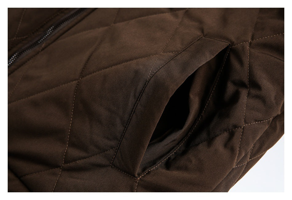 Close-up of a dark brown quilted jacket’s angled pocket opening beside the zipper.
