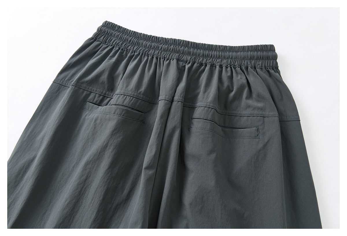 Upper back of charcoal-gray trousers with an elastic waistband and two welt pockets.