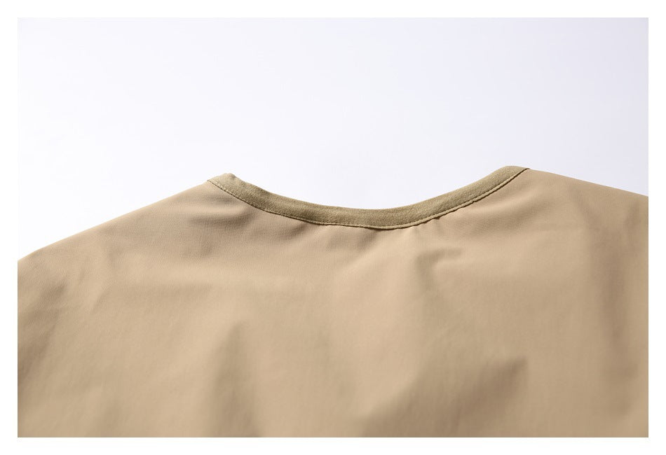 Close-up of the tan garment's back neckline with darker binding.