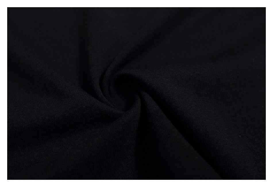 Close-up of black T-shirt fabric gathered into a spiral-like fold.