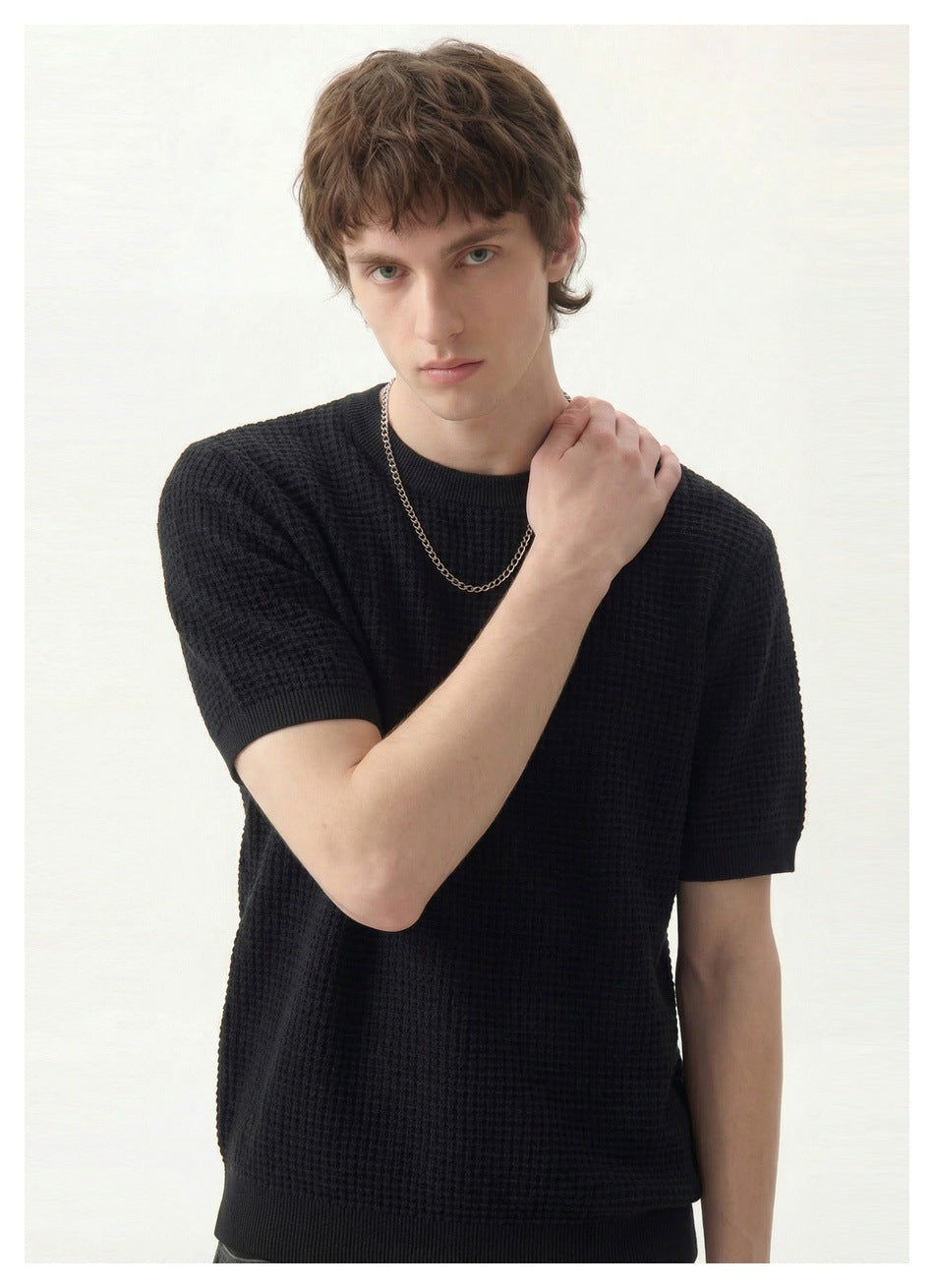 Close view of a model wearing a black textured short-sleeve crew-neck shirt.
