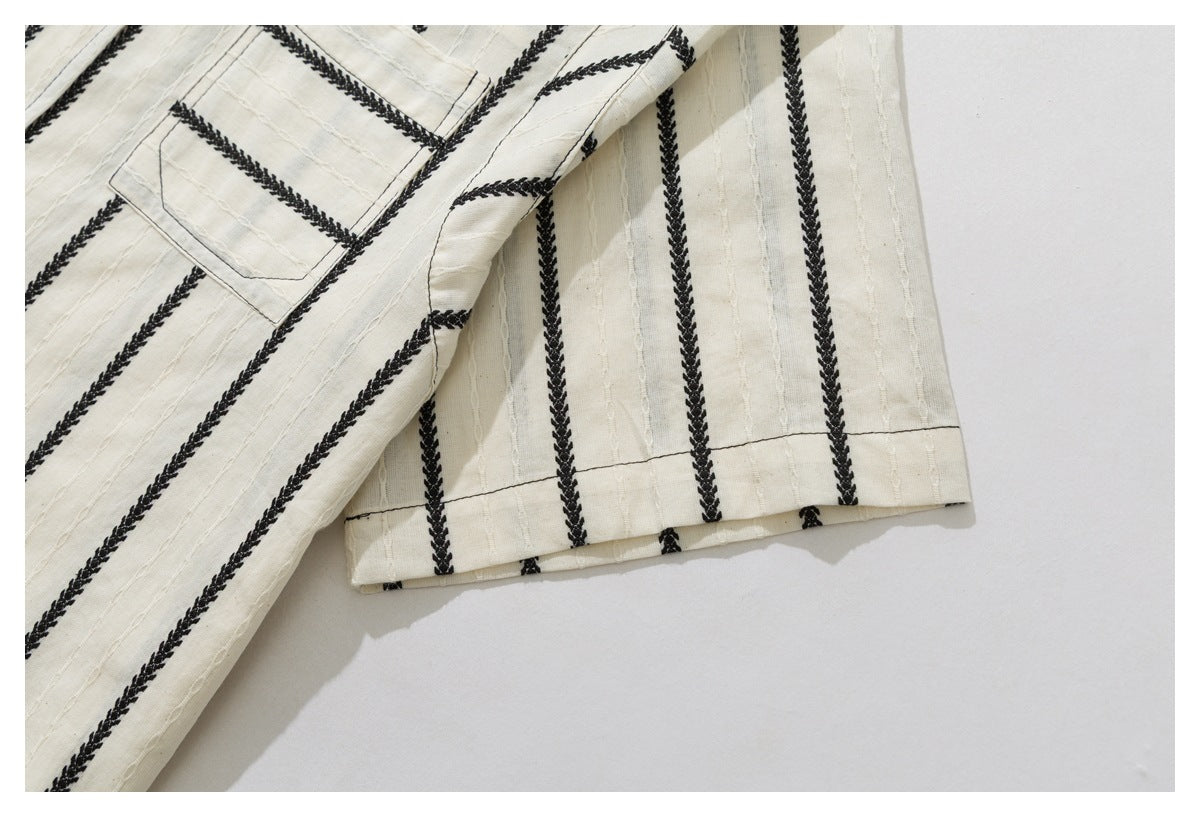 Close-up of the ivory shirt's striped sleeve and hem, with part of the chest pocket visible.