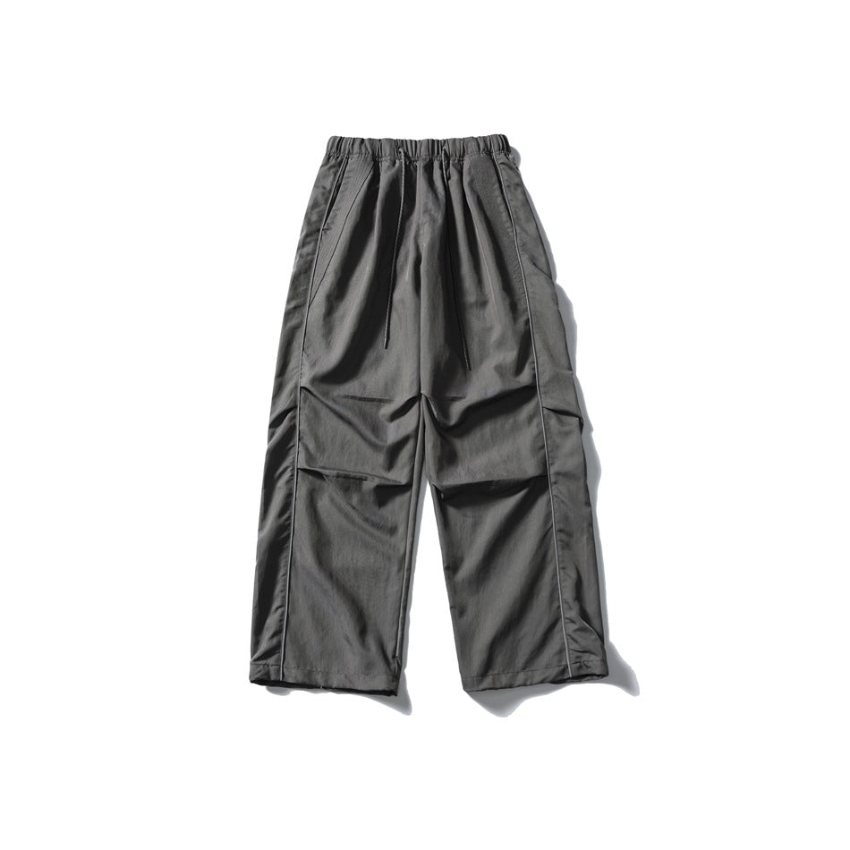 Gray wide-leg drawstring pants with elastic waistband and side piping, flat lay front view