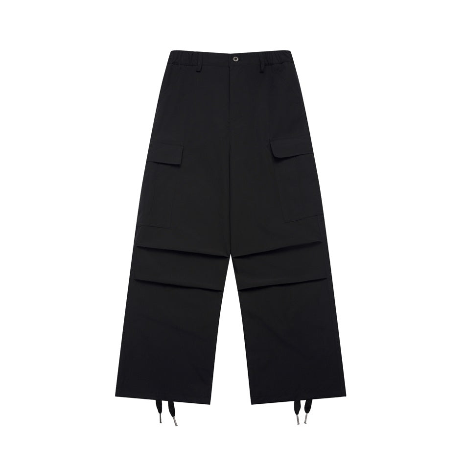 Black wide-leg cargo pants flat lay with flap side pockets, knee pleats and drawstring hems