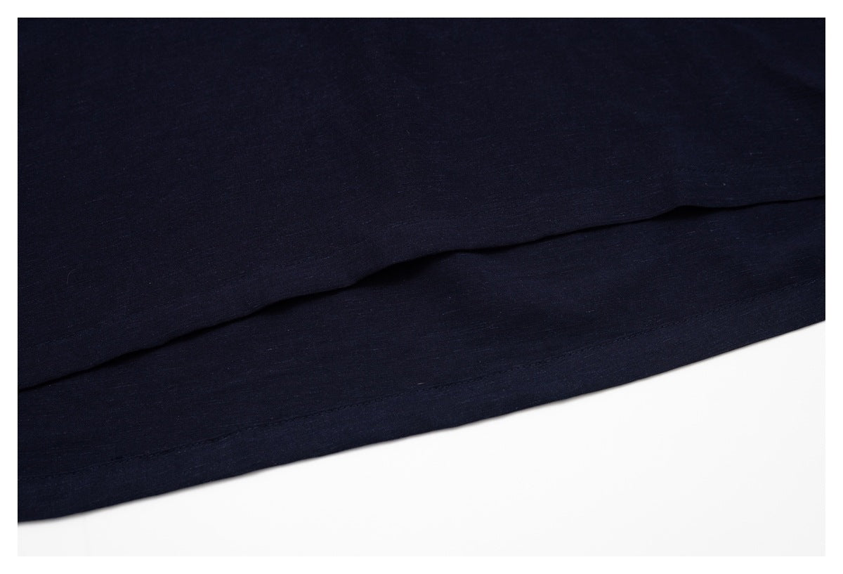 Close-up of the dark navy shirt's hem and stitched edge.
