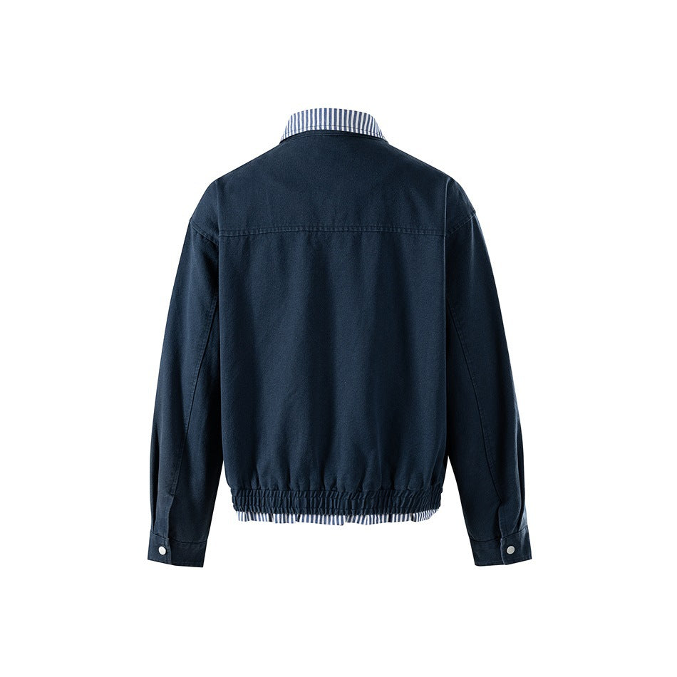 Back view of navy jacket showing yoke seam, elastic gathered hem, striped hem trim and snap cuffs