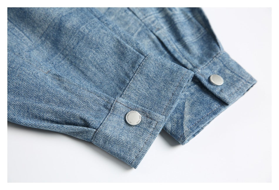 Close-up of blue denim sleeve cuffs with silver button closures.