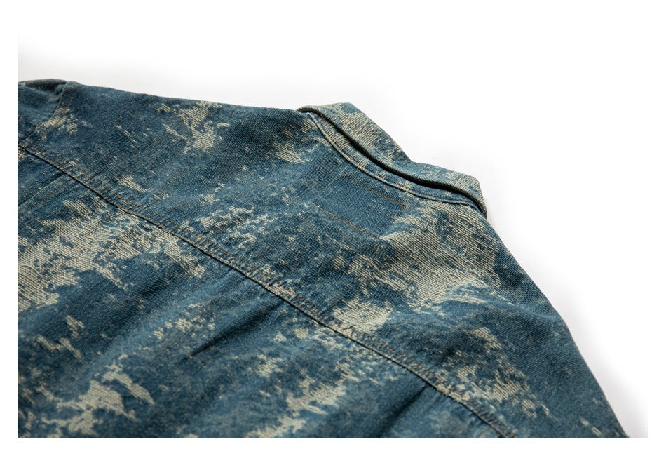 Close-up of the back shoulder and yoke seam on a blue distressed denim jacket.