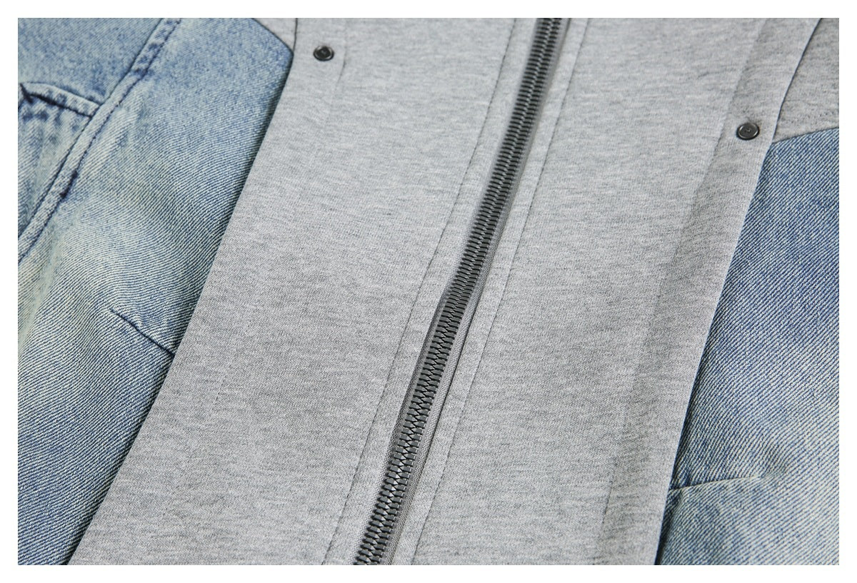 Close-up of the jacket's central zipper, snap fasteners, and contrasting blue denim side panels.