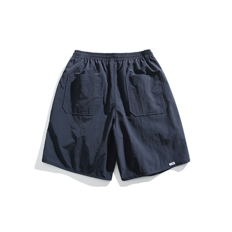 Back view of dark navy shorts with an elastic waistband and two large rear patch pockets, on a white background.